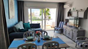 a living room with a table and chairs and a couch at Beautiful 1 bedroom apartment in Roquetas de Mar