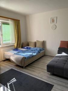 ein Schlafzimmer mit einem Bett, einem Sofa und einem Fenster in der Unterkunft Wohlfühloase Leoben in Leitendorf