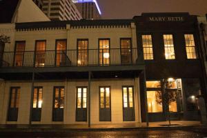 um grande edifício branco com uma varanda em cima em The Mary Beth Hotel & Gallery em Nova Orleans