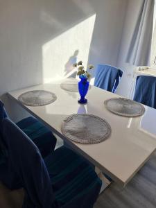 einen Tisch mit drei Stühlen und eine Vase mit Blumen darauf in der Unterkunft Wohlfühloase Leoben in Leitendorf