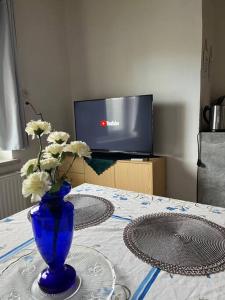 eine blaue Vase mit weißen Blumen auf einem Tisch in der Unterkunft Wohlfühloase Leoben in Leitendorf