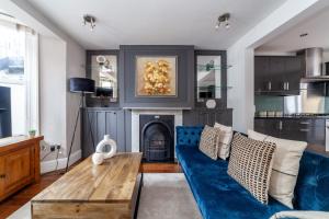 The Hammersmith Villa في لندن: غرفة معيشة مع أريكة زرقاء ومدفأة