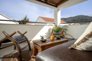 a balcony with a couch and a table and chairs at Luxury Apartment Flora, Stari Grad, Hvar Island in Stari Grad