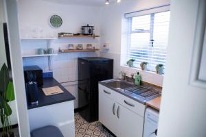 uma cozinha com um lavatório e um frigorífico preto em Laburnum No.4 by Oracle em Stratford-upon-Avon