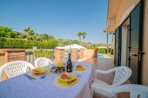 a table with plates of food and a bottle of wine at Villa Trinacria, Piedimonte Etneo in Presa