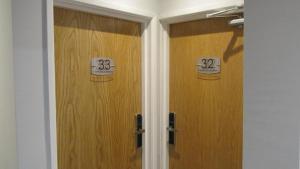 twee houten deuren met nummers erop in een kamer bij Rooms at The Ritz Complex in Desborough