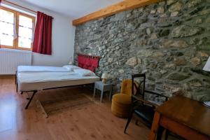 Un dormitorio con una cama en una pared de piedra. en Gîte Neige Cordier - Villar d'Arène center 2 bedrooms and large terrace, en Villar-dʼArène 17 fotos más