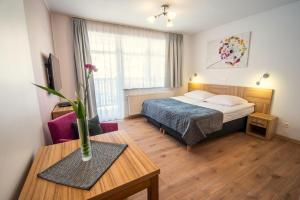 a hotel room with a bed and a table at Malina Apartamenty in Szklarska Poręba