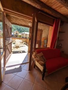 a living room with a red couch and a large window at Gîte Neige Cordier - Villar d'Arène center 2 bedrooms and large terrace in Villar-dʼArène