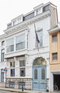 a white building with a flag in front of it at Maison d'Artiste in Ghent