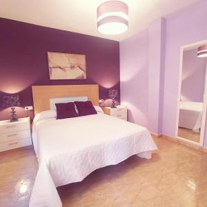 1 dormitorio con cama blanca y paredes moradas en Playa de Levante, Céntrico, AC, Wifi y Parking - by Aloha Palma, en Águilas