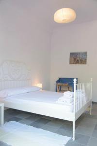 a bedroom with a white bed and a lamp at Melinda Holiday House in Plomarion