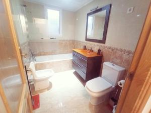 a bathroom with a toilet and a sink and a tub at Playa de Levante, Céntrico, AC, Wifi y Parking - by Aloha Palma in Águilas