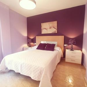a bedroom with a white bed and purple walls at Playa de Levante, Céntrico, AC, Wifi y Parking - by Aloha Palma in Águilas