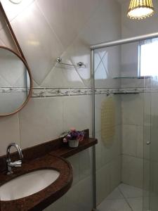 a bathroom with a sink and a glass shower at Apartamento/Flat em Jacumã in Conde