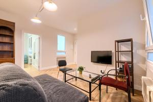 a living room with a couch and a tv at Euskalduna Apartamento Moderno y Renovado in Bilbao