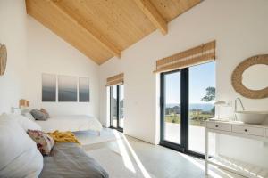 1 dormitorio con 2 camas, lavabo y ventanas en itacahomes casa NORO, en Ribeira