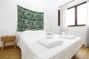 a white room with two beds with towels on them at Windmill 2 Bed Apartment in Odiaxere in Odiáxere