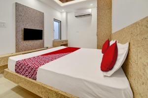 1 dormitorio con 1 cama grande con almohadas rojas en OYO Flagship Hotel Laxmi Inn en Kota