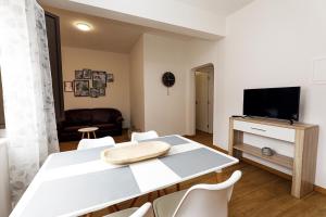 a living room with a white table and a tv at Windmill 2 Bed Apartment in Odiaxere in Odiáxere