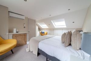 a bedroom with a white bed and a yellow chair at The Hammersmith Villa in London