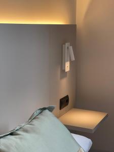 um quarto com uma cama com uma luz na parede em AZ Hotel San Valero em Zaragoza