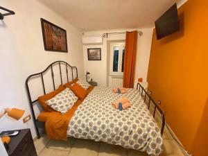 una camera da letto con letto completo di lenzuola e cuscini arancioni di La Casa Rossa Arcola Con Vista ad Arcola