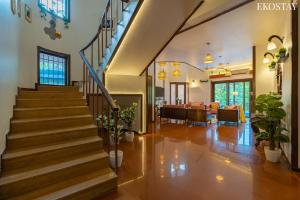 a living room with a staircase in a house at EKOSTAY - Gold -Casa Pino in Candolim