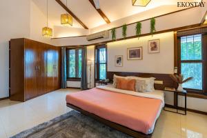 a bedroom with a large bed in a room at EKOSTAY - Gold -Casa Pino in Candolim +33 photos