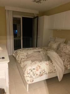 duże łóżko w sypialni z oknem w obiekcie Cocotte au zoute w mieście Knokke-Heist