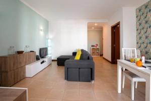 a living room with a couch and a television at The Albufeira Concierge - Modern Salgados in Albufeira