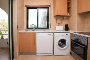 a kitchen with a washing machine and a sink at The Albufeira Concierge - Modern Salgados in Albufeira