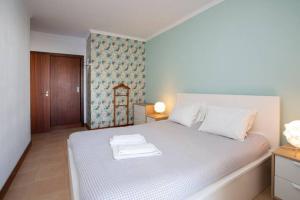 a bedroom with a bed with two towels on it at The Albufeira Concierge - Modern Salgados in Albufeira