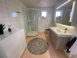 y baño con bañera, lavamanos y ducha. en Damperiholmen cabin en Sund