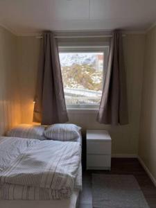 1 dormitorio con 2 camas y ventana en Damperiholmen cabin en Sund