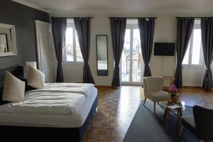 a bedroom with a large bed and a chair at Boutique-Hotel Antica Posta in Ascona