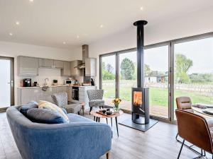 a living room with a blue couch and a fireplace at 2 bed in East Bergholt 82400 in East Bergholt
