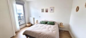 a bedroom with a bed with two green pillows at Résidence Le Mans in Le Mans +10 photos