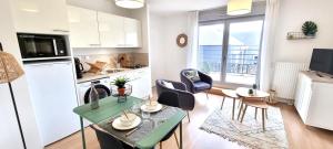 a kitchen and living room with a table and chairs at Résidence Le Mans in Le Mans