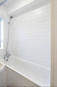 Baño blanco con bañera y lavamanos en Single Room - Kings Cross, Female Only,, Guest House, en Londres