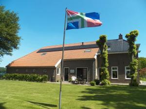 una bandera ondeando frente a una casa en Bij Leentjer geheel appartement, 