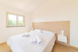 a white bedroom with a bed with towels on it at Villa Trinacria, Piedimonte Etneo in Presa