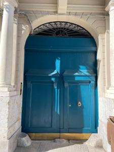 une grande porte de garage bleue dans un bâtiment dans l'établissement La casa di Chele, à Palerme
