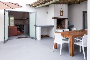 a dining room with a wooden table and a fireplace at Karibu in Paternoster