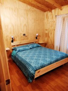 1 dormitorio con 1 cama grande en una habitación en Cabañas Volcán Dormido, Hornopirén, en Hornopirén