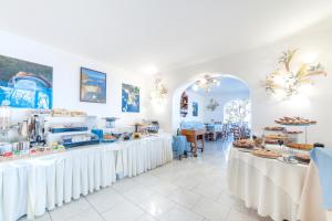 a room with white tables with food on them at Punta Chiarito Resort in Ischia