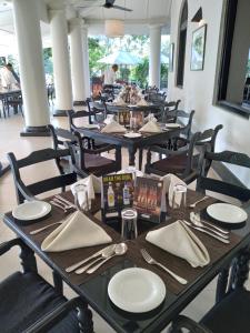 a dining room with tables and chairs with plates and napkins at The Heritage Ambepussa in Ambepussa