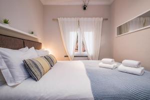 a bedroom with a white bed with towels on it at Sant'Ana Cottage in Cascais