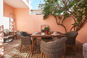 a wooden table and chairs on a patio at Sant'Ana Cottage in Cascais
