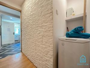 a hallway with a stone wall next to a refrigerator at Amber Studio in Gdańsk